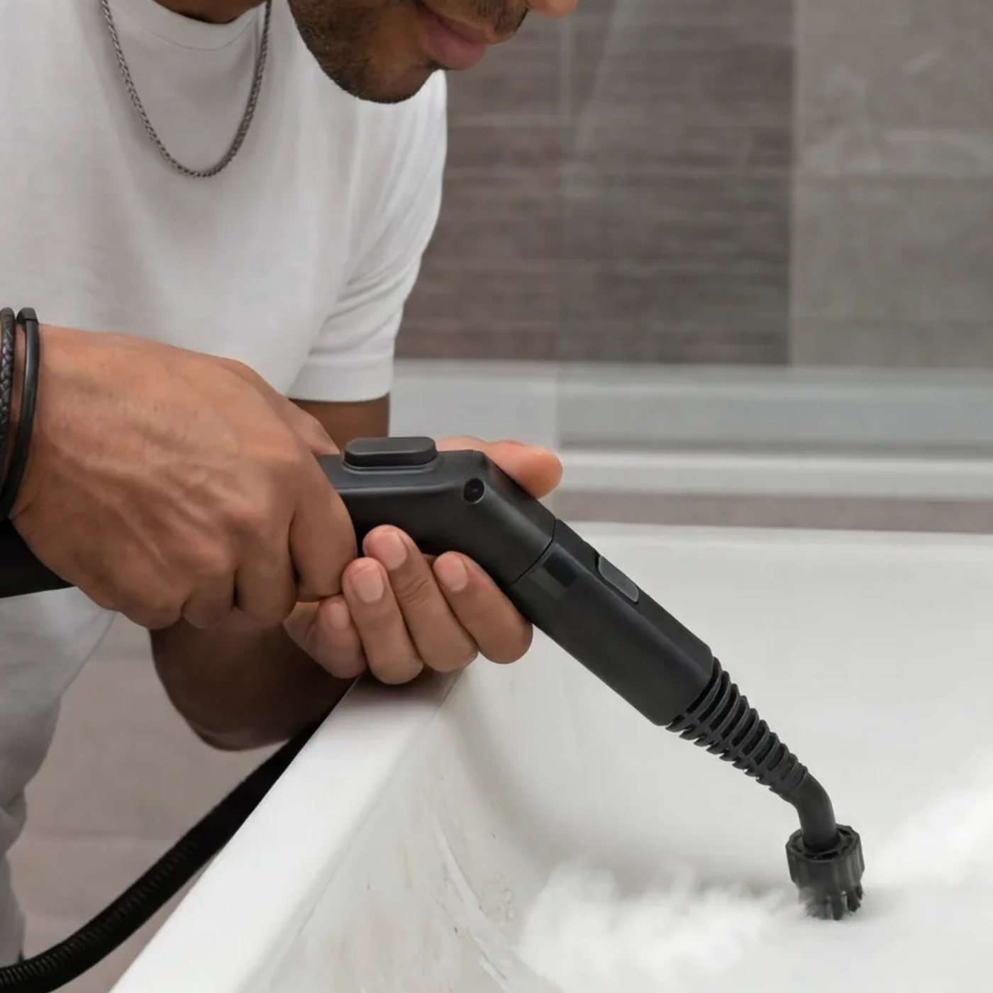 Homme désinfectant un lavabo de salle de bain à la vapeur sans produits chimiques